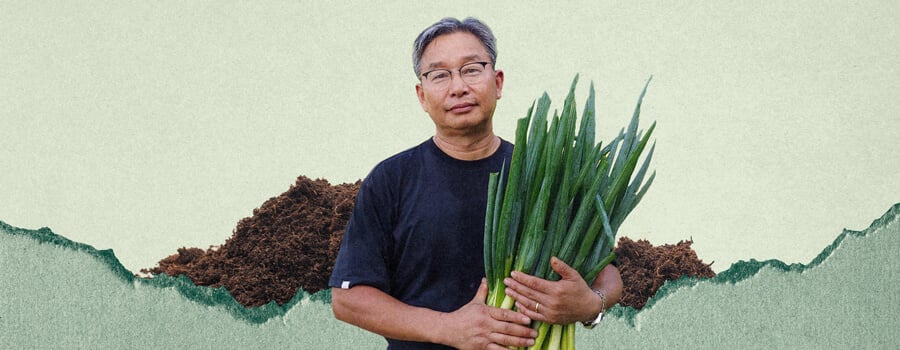 Een man genaamd Youngsang Cho houdt een bos groene uien vast. Hij staat voor een hoop aarde.